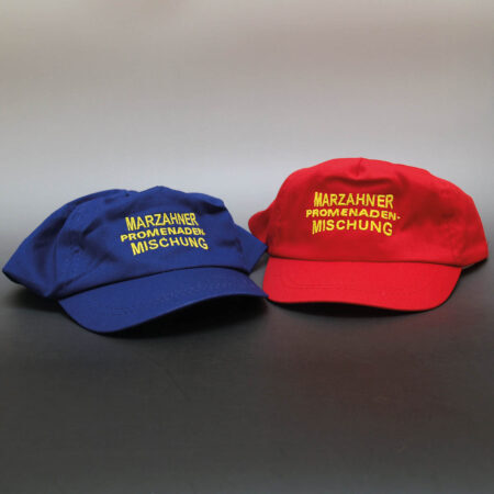 Basecap in rot und blau aus Baumwolle und individueller Bestickung für den Kinderchor „Marzahner Promenaden-Mischung“.